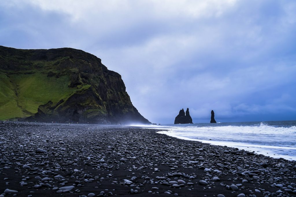 black sand beach sea steaks are considered as trolls in iceland