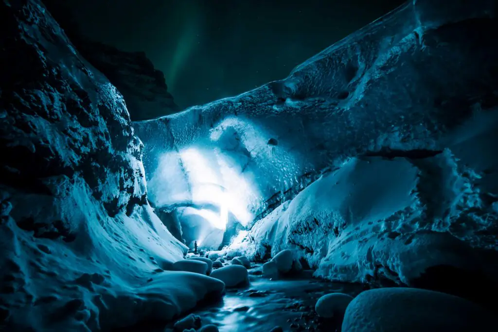 Icy snow on cliffs with the northern lights in the background